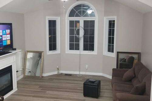 a living room with a couch and a flat screen tv at Cozy Luxurious Detached 4 Bedroom House in Guelph