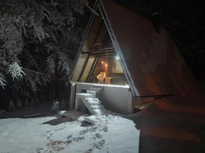 una piccola casa nella neve con una luce di VILA MAGDA a Divčibare