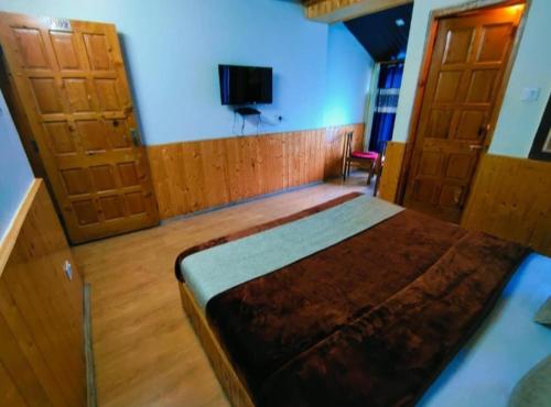 a bedroom with a bed and two wooden doors at hotel jupiter tamilnadu in Ooty