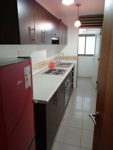 a kitchen with a red refrigerator and a sink at Genial Ubicación, cerca de todo! in La Serena