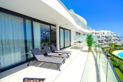 balkon z krzesłami i basen w budynku w obiekcie Mara's Apartments Higueron West - Mediterranean Style - Beach & Golf - Large Sunny Terrace !!!! w mieście Fuengirola