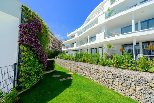 a building with a retaining wall next to a garden at Mara's Apartments Higuerón West - Mediterranean Style - Beach & Golf - Large Sunny Terrace in Fuengirola