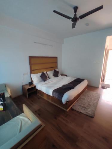 a bedroom with a bed and a ceiling fan at The King Hill in Ketti