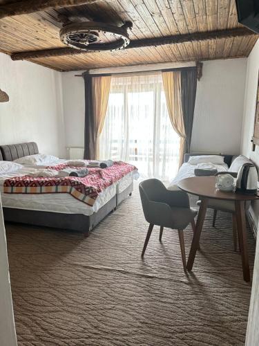 a bedroom with two beds and a table and a window at SPA HOTEL Gora in Bukovel