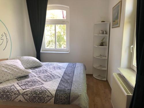 a bedroom with a bed and a window at Marktresidenz Eisenach- Stilvolle Maisonette mit 3 Zimmern und 2 Bädern in Eisenach