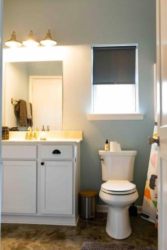 a bathroom with a toilet and a sink and a mirror at Clean & Serene House Studio - Easy Onoff I-40 in Memphis
