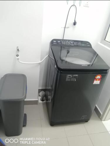 a bathroom with a trash can next to a toilet at Rizqi Homestay Seruling in Putrajaya