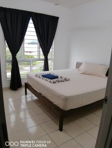 un letto in una camera con una grande finestra di Rizqi Homestay Seruling a Putrajaya