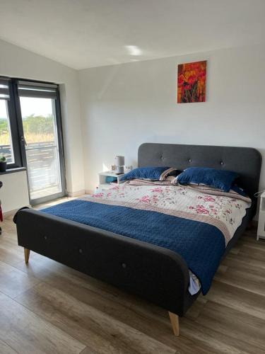 a large bed in a bedroom with a large window at Mimi house in Baia de Fier