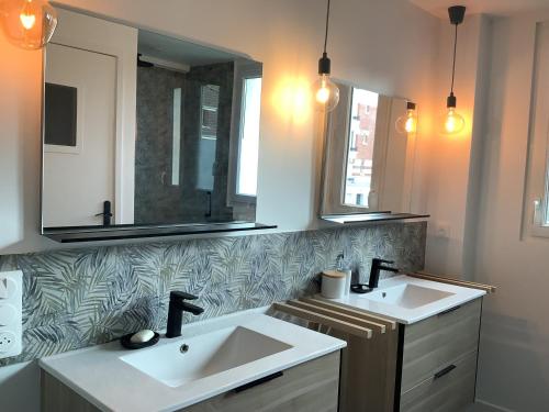 une salle de bain avec deux lavabos et deux miroirs dans l'établissement Paris Bécon, à Asnières-sur-Seine