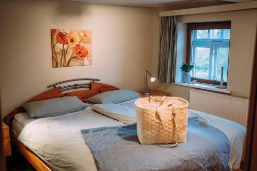 a bedroom with a bed with a basket on it at Kalle´s Reethus in Pellworm