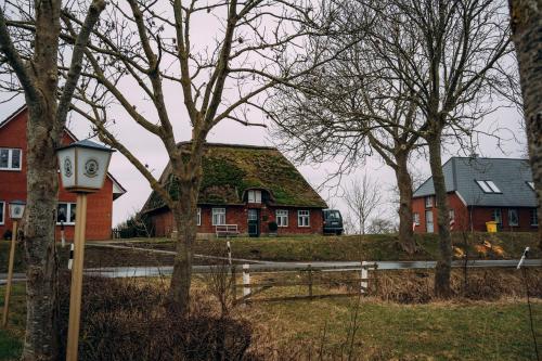 a house with a clock in front of it at Kalle´s Reethus in Pellworm