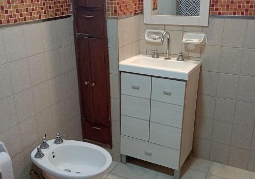 a bathroom with a sink and a toilet and a mirror at Bungalows El Zarateno in Colón