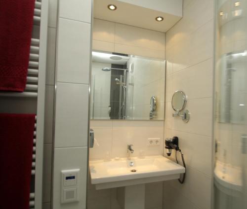 a bathroom with a sink and a mirror at Hotel-Restaurant Goldenstedt in Delmenhorst