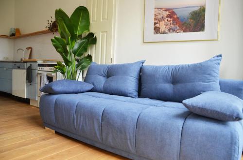 un divano blu con cuscini in soggiorno di Gemütliches Messe und Ferienapartment 60m2 nähe Kölnmesse & LANXESS Arena a Colonia