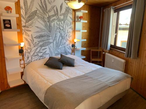une chambre avec un lit avec deux oreillers dessus dans l'établissement Aravis 1500, No 4, Appartement 3 pièces, Vue montagne, à La Clusaz