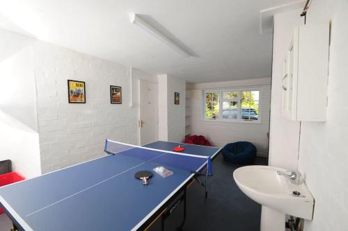 Habitación con mesa de ping pong y lavabo. en Newly refurbished town house in Warwick en Warwick