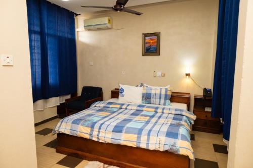 - une chambre dotée d'un lit avec des rideaux bleus dans l'établissement Freeman Methodist Guest House, 