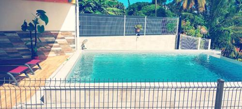 a swimming pool with blue water in front of a house at Le Nid De Nicolas in Saint Esprit