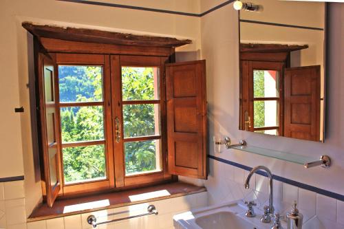 baño con ventana, lavabo y espejo en Agriturismo la Torre, en Bagni di Lucca