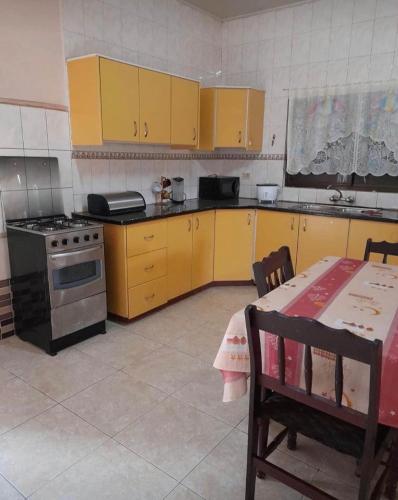 a kitchen with yellow cabinets and a table and a stove at Kapowlito Real Estate Casa Sitalweg in Paramaribo