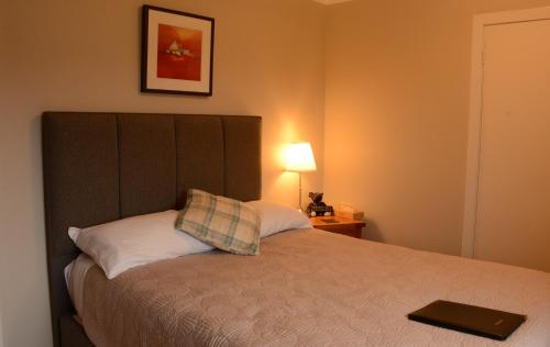 a bedroom with a bed with a laptop on it at Lochview House in Fort William