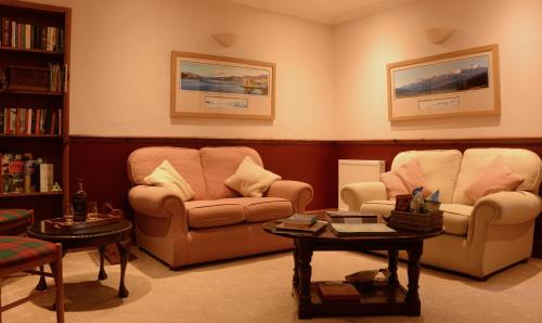 a living room with three chairs and a table at Lochview House in Fort William