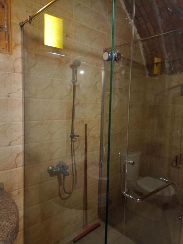 a shower with a glass door and a toilet at Rahala Safari Hotel in Qasr Al Farafirah