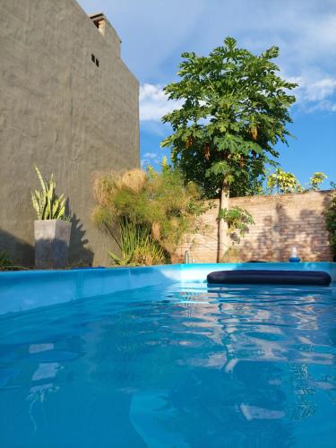 una piscina de agua azul frente a un edificio en Casa con pileta en Yerba Buena en Yerba Buena