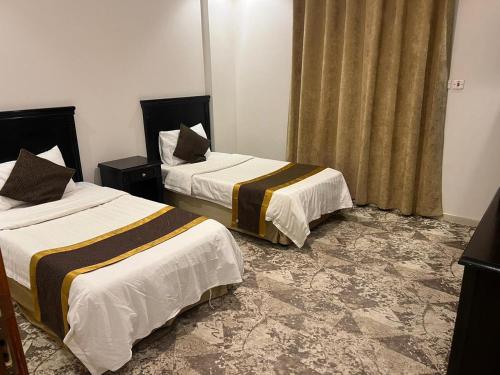 2 Betten in einem Hotelzimmer mit Röcken in der Unterkunft Al Joud Palace Residential Units in Abha