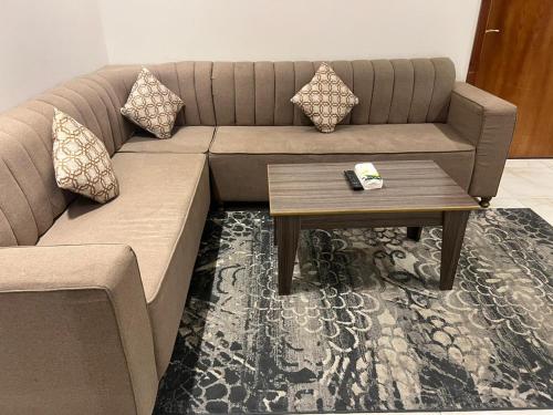 uma sala de estar com um sofá e uma mesa de centro em Al Joud Palace Residential Units em Abha