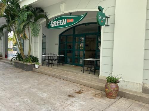 a green inn with tables and chairs in a building at Green Inn Phu Quoc Hotel in Phu Quoc