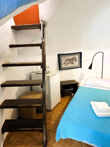 a room with a ladder next to a bed at Lioyerma Windmill Villa With Outdoor Hot Tub in Oia