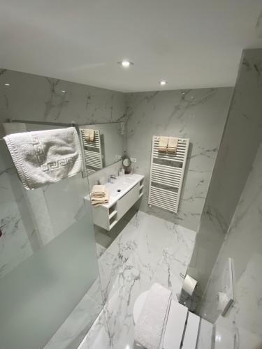 a white bathroom with a sink and a mirror at Magici momenti-Bordighera in Bordighera