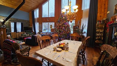 a dining room with a table and a christmas tree at Le Gite A Margot in Bromont