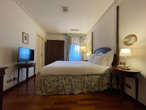 a hotel room with a bed and a television at Hotel Villa Luppis in Pasiano di Pordenone