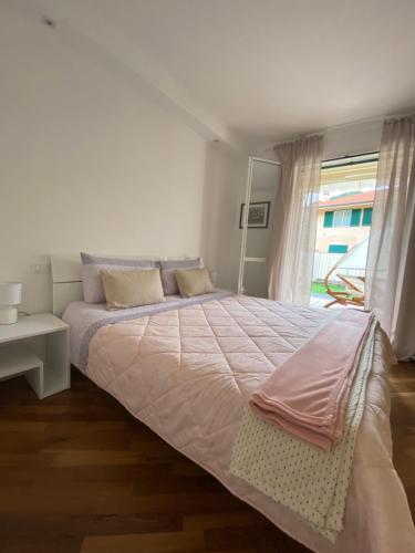 a white bedroom with a large bed and a window at Magici momenti-Bordighera in Bordighera