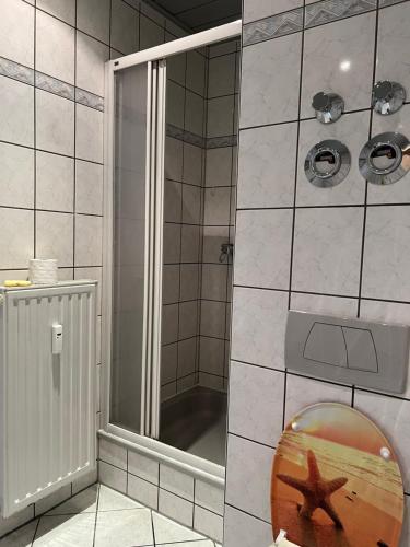 a bathroom with a shower with a starfish on the floor at Ferienwohnung in Walddorf