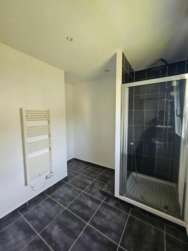 baño con ducha y suelo de baldosa. en Maison 3 chambres 5min de paimpol, en Kerfot