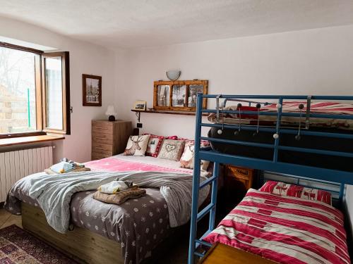 a bedroom with two bunk beds and a window at Sauze d'Oulx with garden, ciabot la garitüla - wifi in Sauze dʼOulx