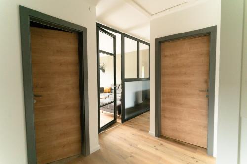 two wooden doors in a room with wooden floors at Ferienhaus Berg'nSee in Annenheim