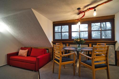 a living room with a table and a red couch at Luisenhof in Neuglobsow