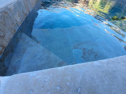 a pool of water with a reflection in the water at Le Mas de Mougins in Mougins