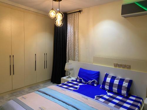 - une chambre avec un lit doté d'oreillers bleus et blancs dans l'établissement Zurik Apartments, à Kusafe