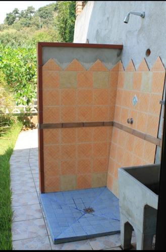 a bathroom with an orange tiled shower with a sink at Case Vacanze Macchione in Capo Vaticano