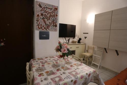 a dining room table with a vase of flowers on it at HOUSE 27 in Fiumicino