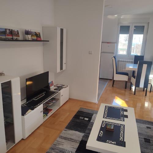 a living room with a television and a table at Black and White in Pirot
