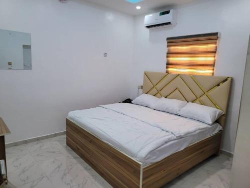 a bedroom with a bed in a white room at B&Y ROYAL BAR & LOUNGE ADIGBE ROAD MONIJESU NEAR ADIGBE POLICE STATION in Abeokuta