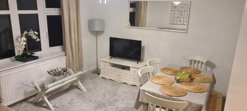 ein Wohnzimmer mit einem Tisch und einem TV in der Unterkunft Hideaway Whitstable in Kent