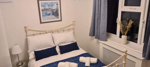 1 dormitorio con 1 cama con almohadas azules y blancas en Hideaway Whitstable en Kent